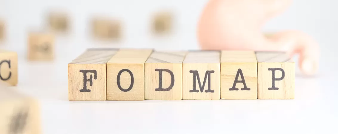 Cuburi din lemn cu litere formand cuvantul FODMAP, concept dietetic destinat gestionarii problemelor digestive