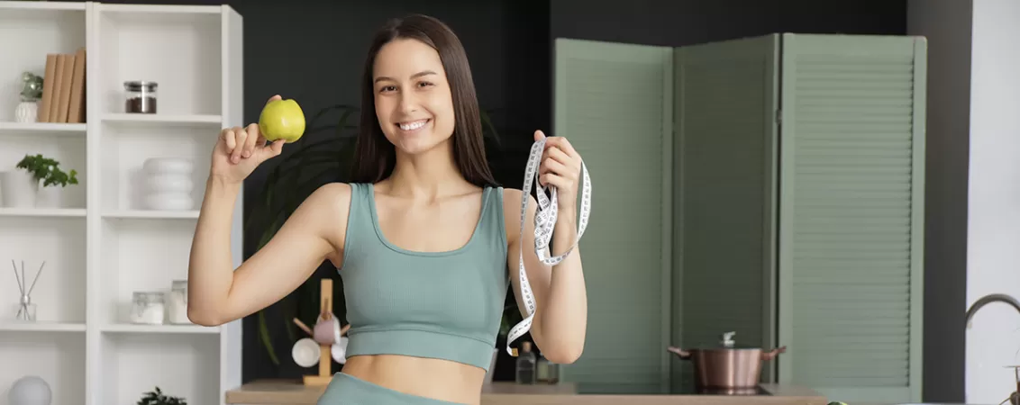 Femeie tanara dupa sport, mancand fructe, ca simbol al unei alimentatii sanatoase