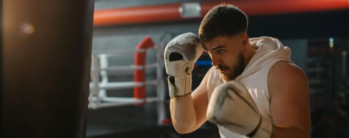 Barbat se antreneaza cu sacul de box
