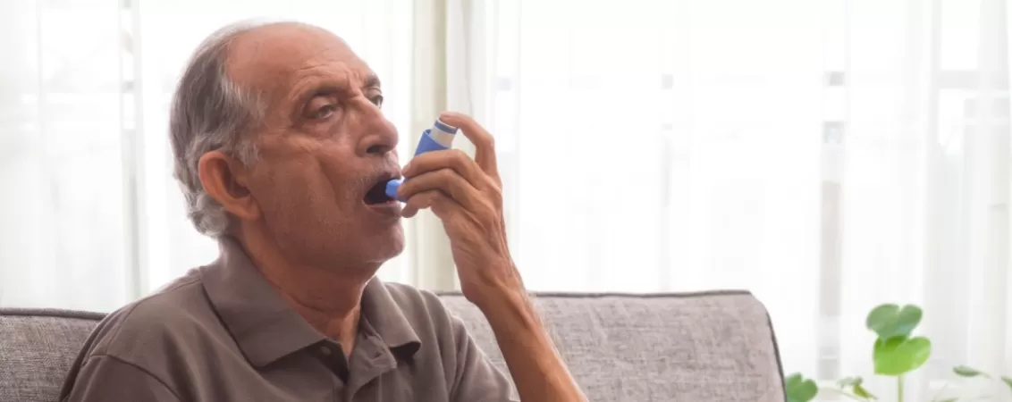 Barbat se pregateste sa foloseasca inhalatorul