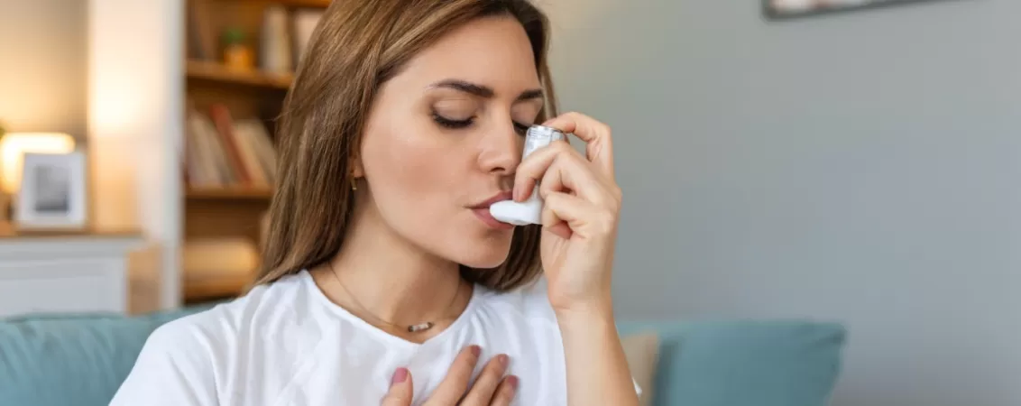 Femeie foloseste inhalatorul