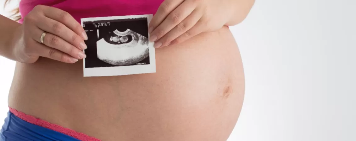 Femeie insarcinata tine in mana o ecografie a bebelusului