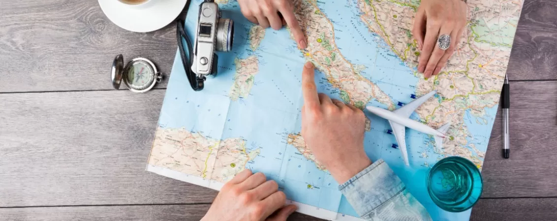 Maini de barbat si de femeie pe o harta așezata pe masa