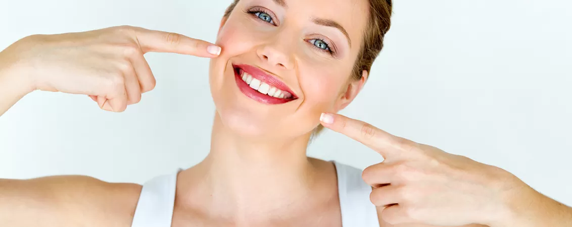 Femeie tânără zâmbește și are dinții albi