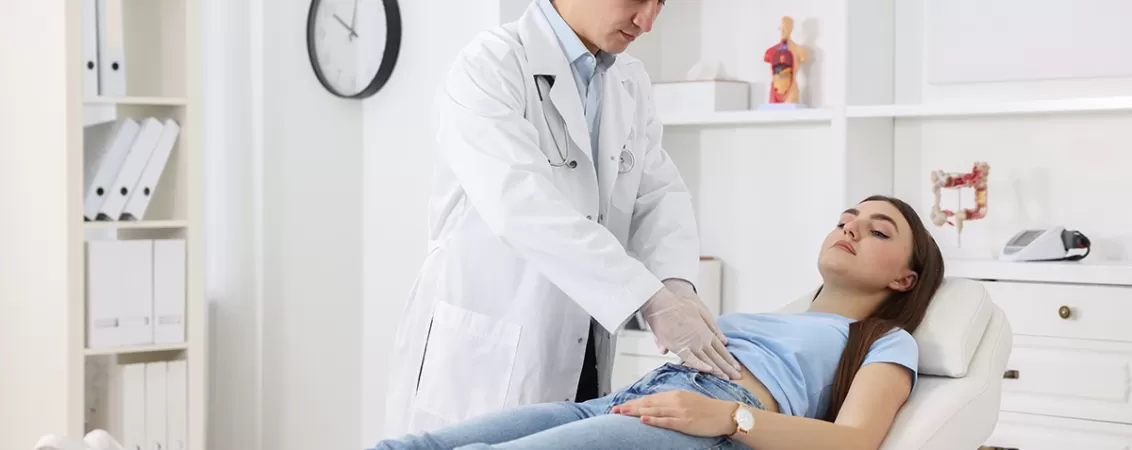 Gastroenterolog examinand un pacient cu dureri abdominale