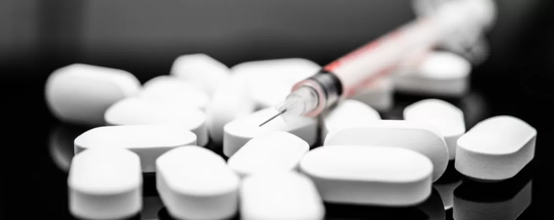 Colectie de pastile albe rotunde, aranjate uniform pe fundal negru – imagine conceptuala a tratamentelor medicamentoase