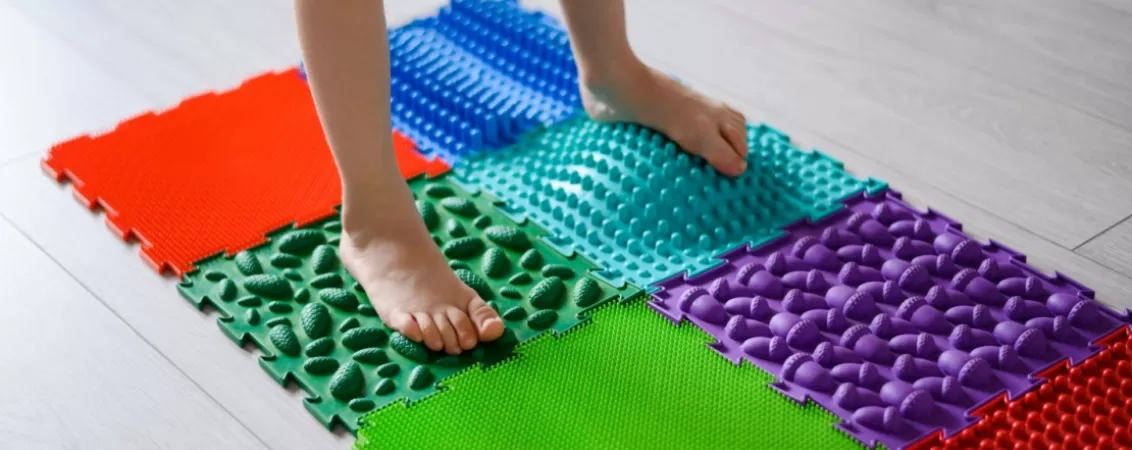Copil merge pe saltea ortopedica cu texturi variate