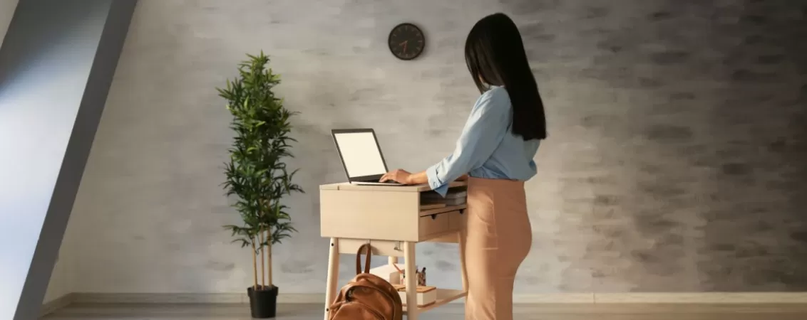 Femeie care tasteaza pe laptop la birou, concentrata la munca