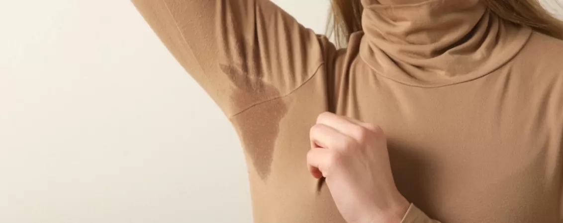 Femeie tanara purtand un pulover bej din bumbac, privire apropiata