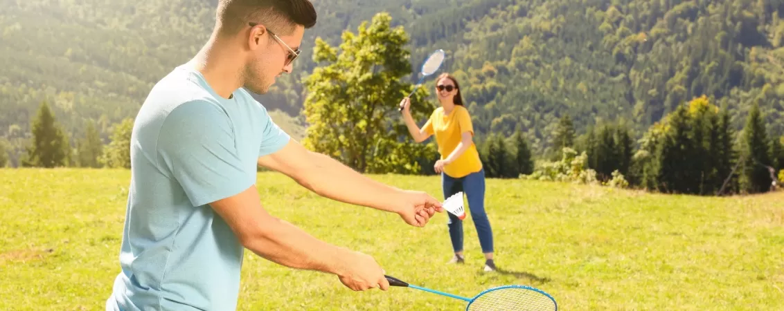 Cuplu joaca badminton la munte