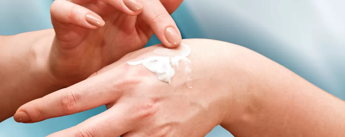 Femeie care aplica crema pe maini cu panthenol pentru ingrijirea pielii