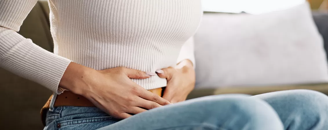 Femeie la menstruație cu mainile pe abdomen