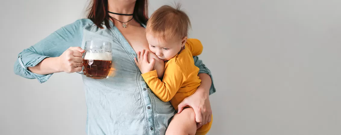 Mama alaptand cu o halba de bere fara alcool in mana