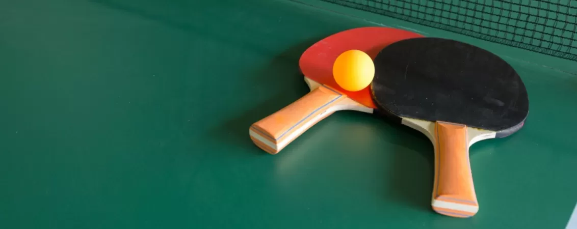 Palete si minge de ping pong pe masa de ping pong