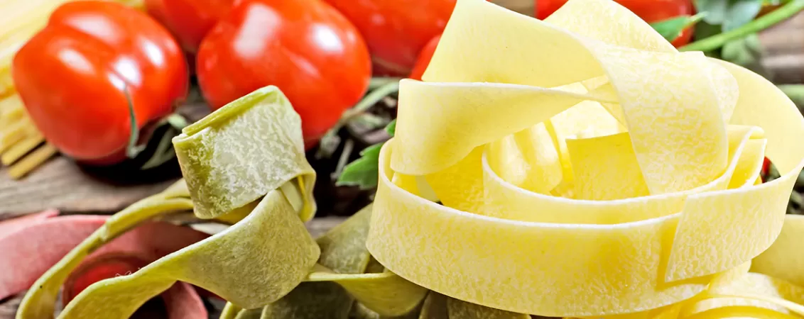 Paste spaghetti si fettuccine din faina integrala asezate pe o masa din lemn, concept de alimentatie echilibrata