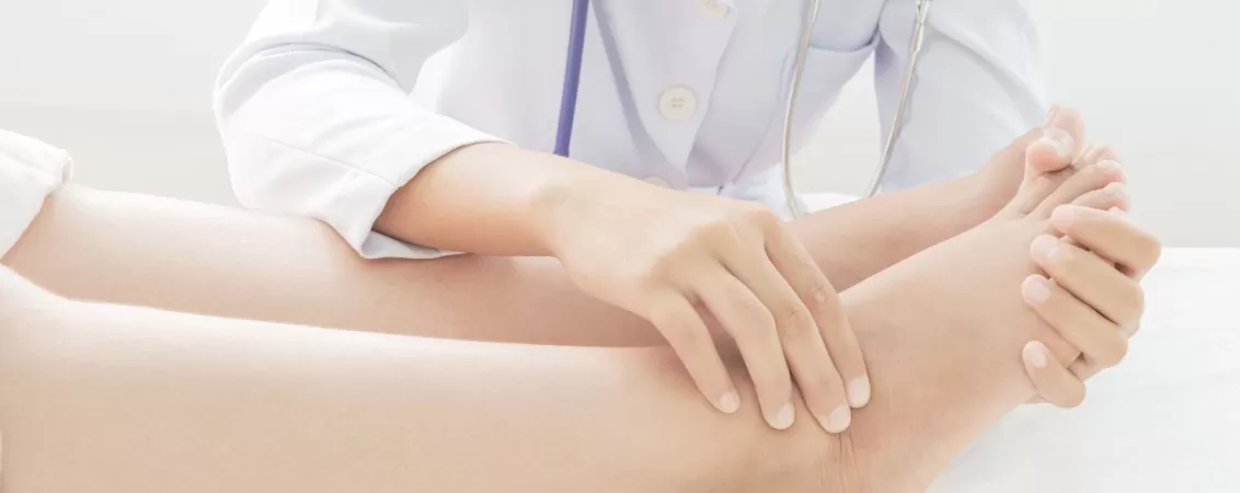Medic examinand o pacienta cu picioare umflate