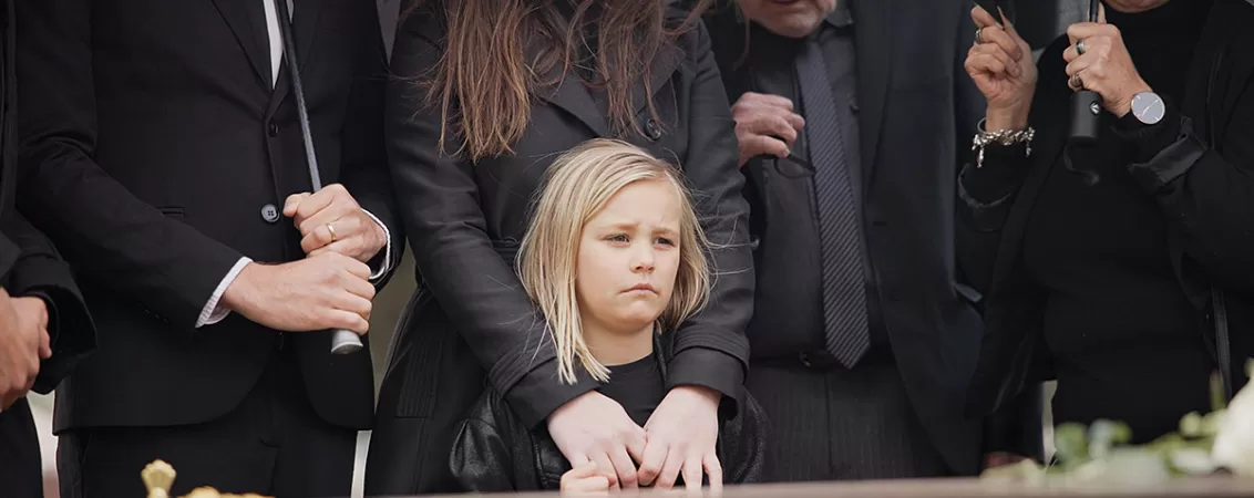 Familie cu o fetita mica la inmormantarea unei persoane dragi