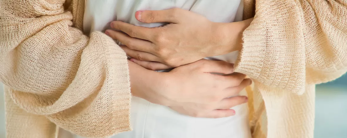 Femeie care isi tine stomacul si simte durere, concept de disconfort gastric sau foame intensa