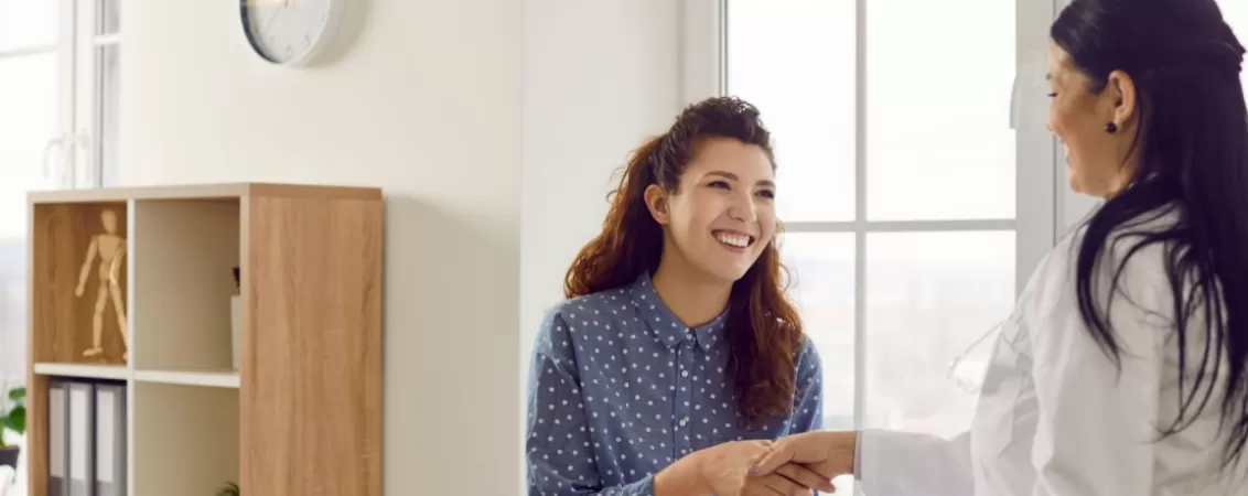 Ginecolog dand mana cu o pacienta venita la control