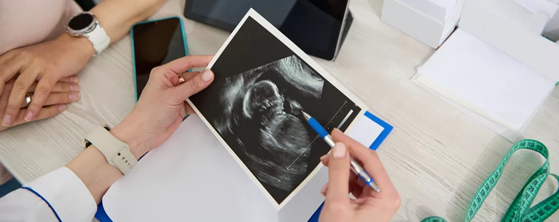 Medic discutand in cabinet cu o pacienta insarcinata pe baza celei mai recente ecografii efectuate