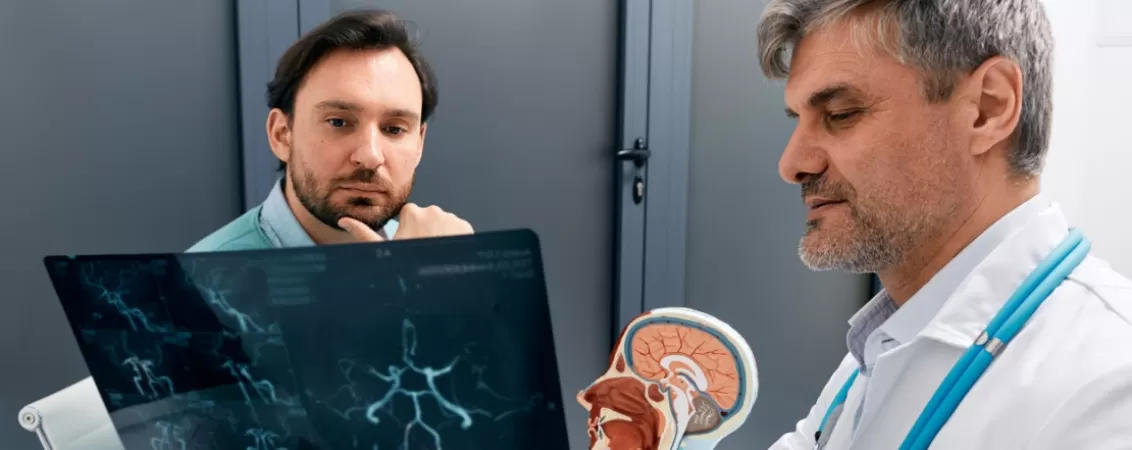 Medic neurolog si pacient discutand rezultatele unei investigatii pentru evaluarea sanatatii sistemului nervos