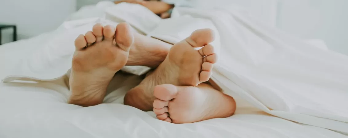 Prim plan picioare cuplu in pat in timpul unui act sexual