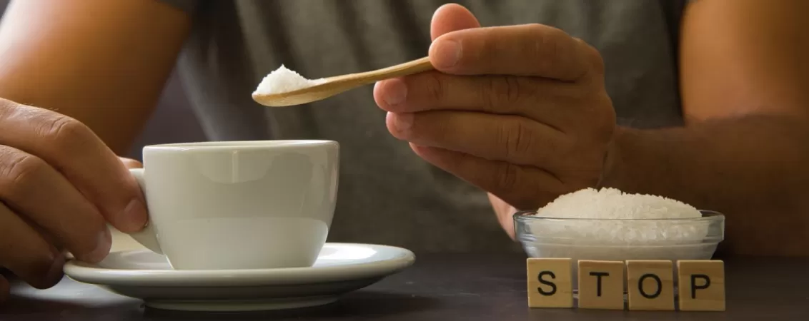 Barbat adauga zahar in cafea