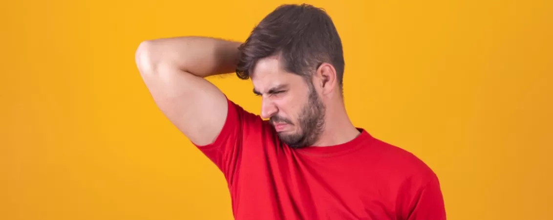 Barbat care simte un miros neplacut al propriului corp