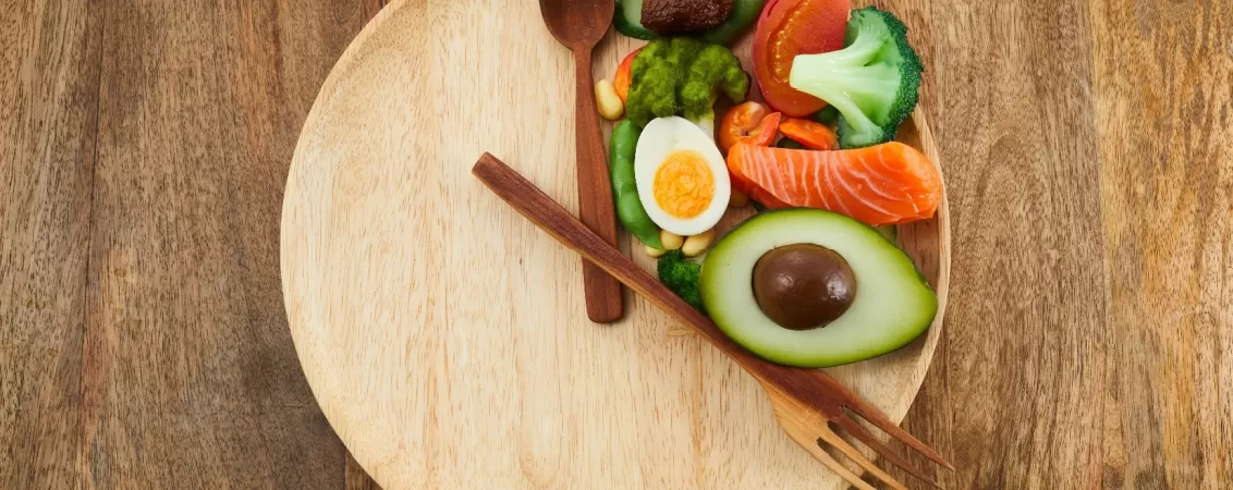 Farfurie cu tacamuri asezate in forma orei 8 si alimente pentru mic dejun sanatos