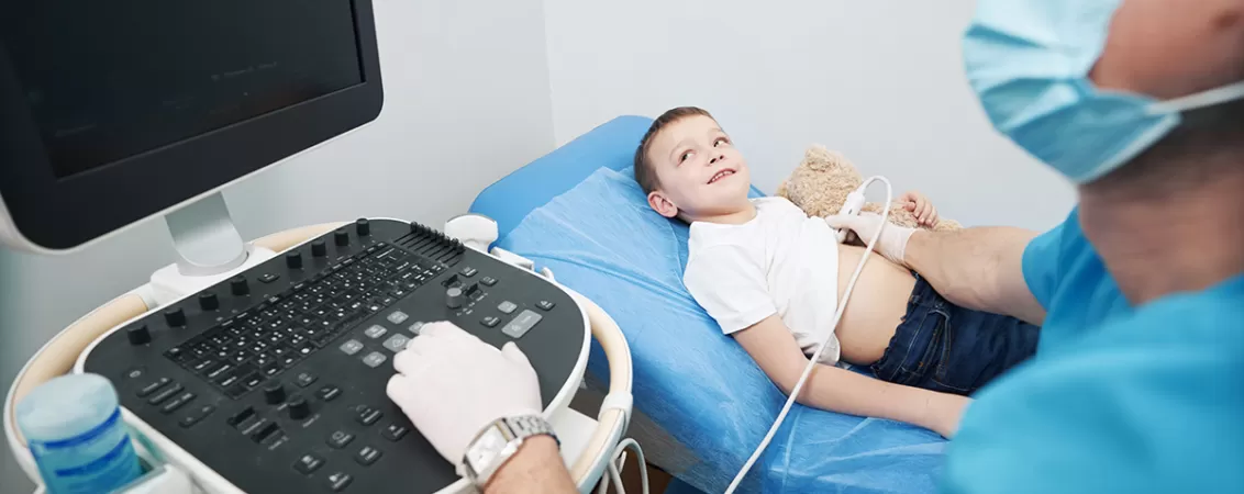 Medic specialist efectuandu-i o ecografie pulmonara unui copil baiat