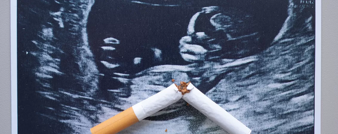 O tigara rupta suprapusa peste o ecografie de sarcina, simbolizand efectele negative ale fumatului in sarcina