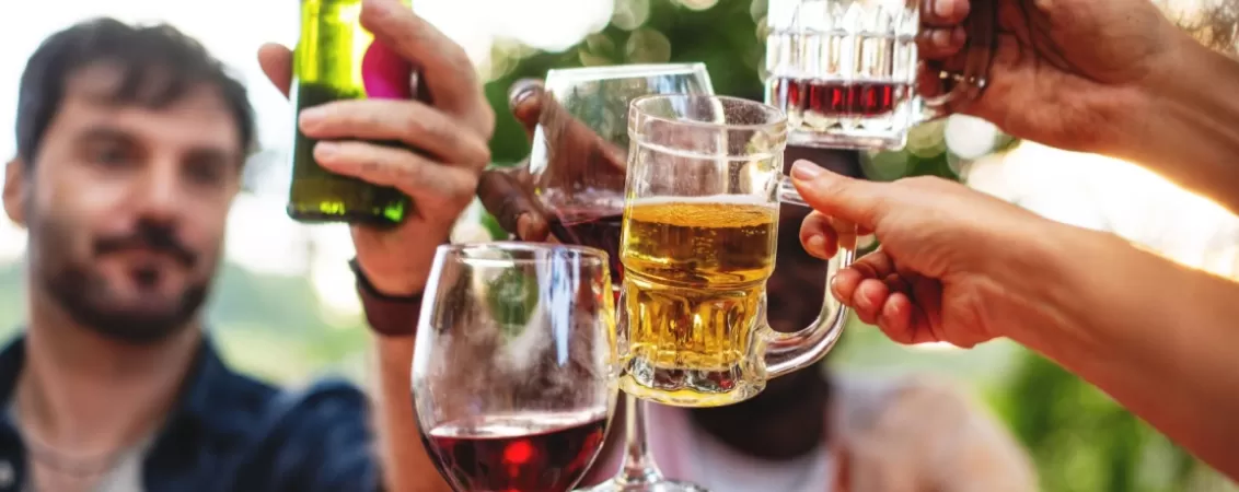Adulti ciocnesc pahare cu bere si vin