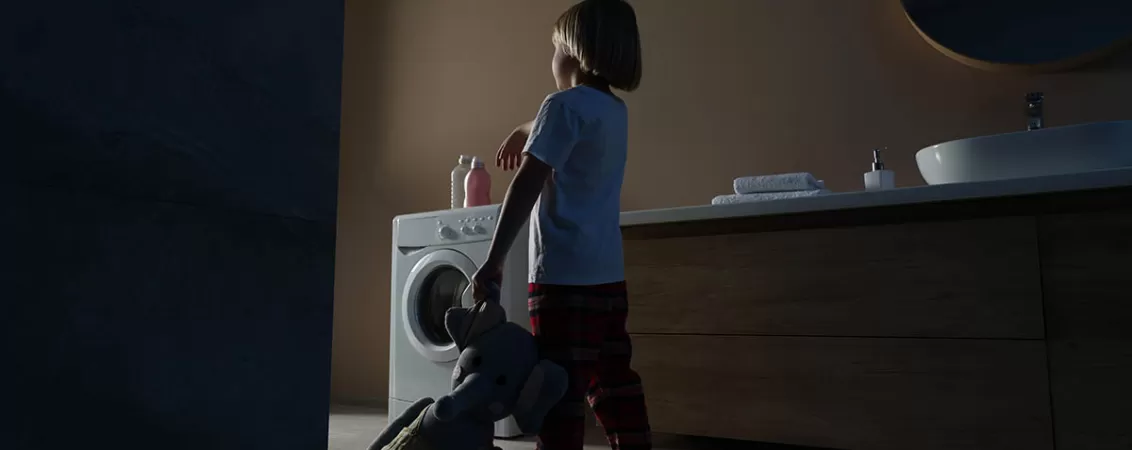 Baietel imbracat in pijamale, tinand un elefant de plus, surprins in timp ce merge somnambul prin camera, ilustrand somnambulismul la copii