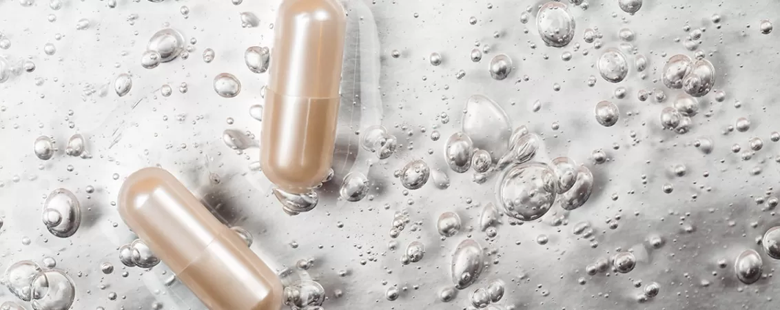 Capsula cosmetica pe fundal gri, simbolizand suplimente pentru frumusete, sanatatea pielii si regenerare celulara