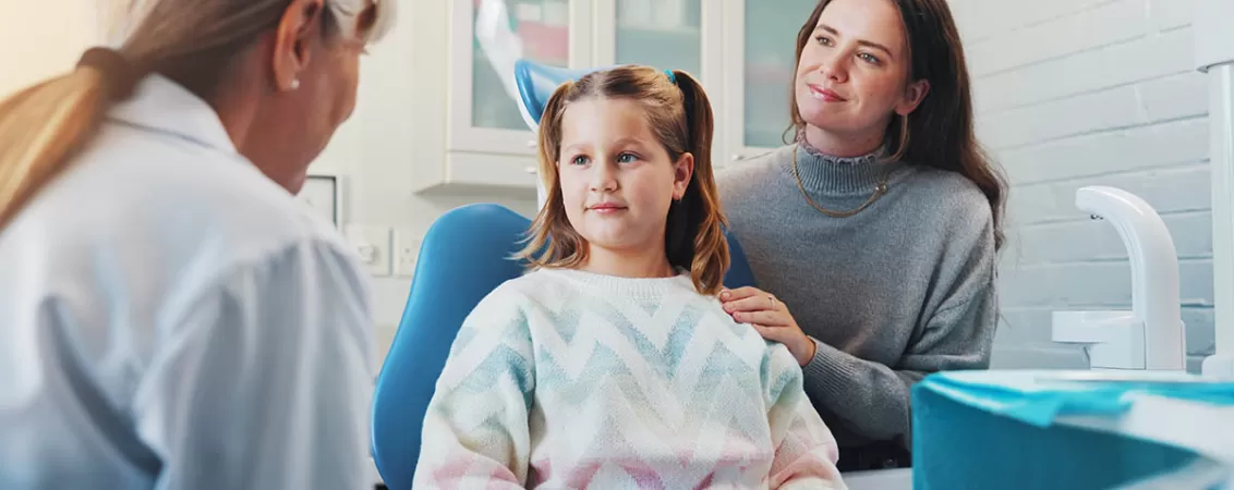 Consultatie stomatologica pentru copil in cabinet dentar, unde medicul verifica igiena orala si sanatatea dintilor, evidentiind importanta controalelor regulate la dentist.