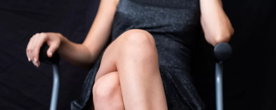 Femeie eleganta sta picior peste picior