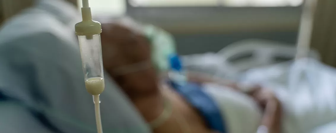 Hranire enterala cu ajutorul unei seringi tip dropper pentru un pacient varstnic, evidentiind procedura medicala de administrare a nutrientilor prin sonda gastrica.