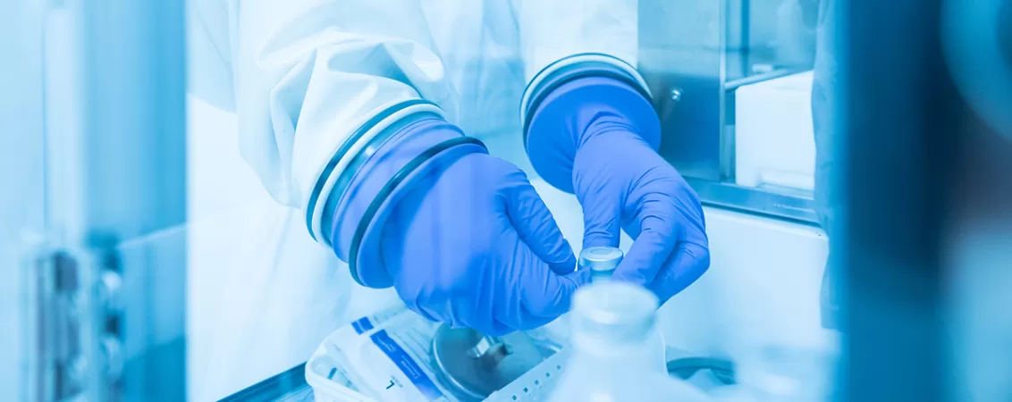 Reprezentant medical cu manusi albastre care lucreaza cu echipament de laborator, analizand probe