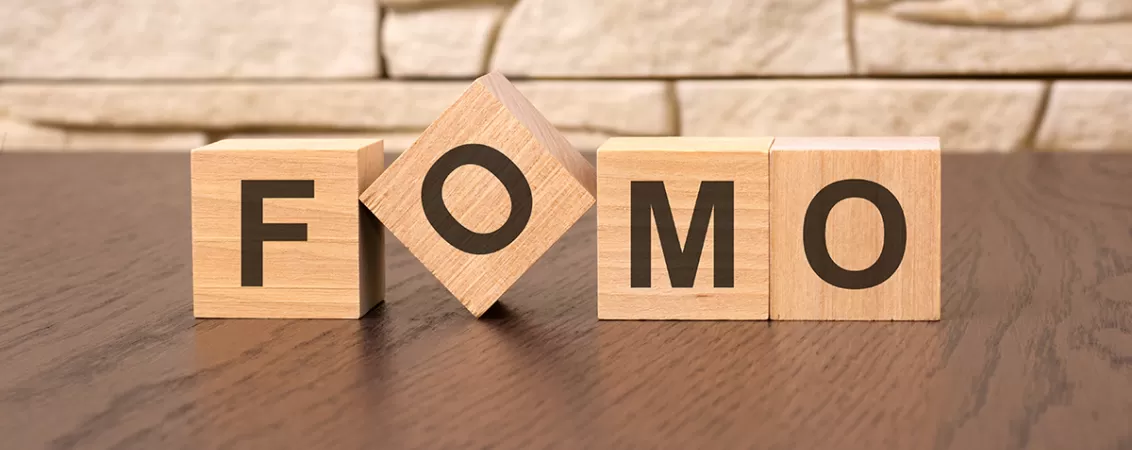 Cuburi din lemn cu litere formand cuvantul FOMO