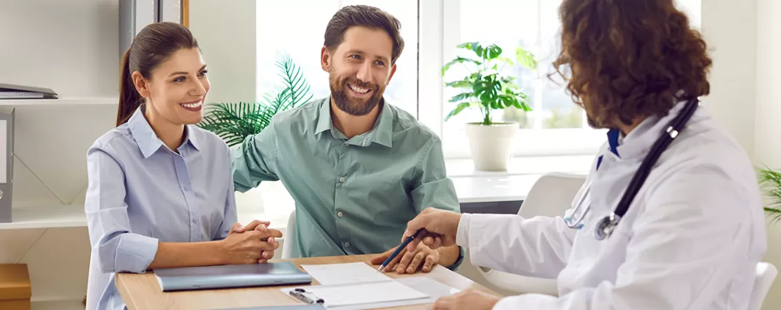 Cuplu discutand cu un medic despre screeningul genetic preconceptional