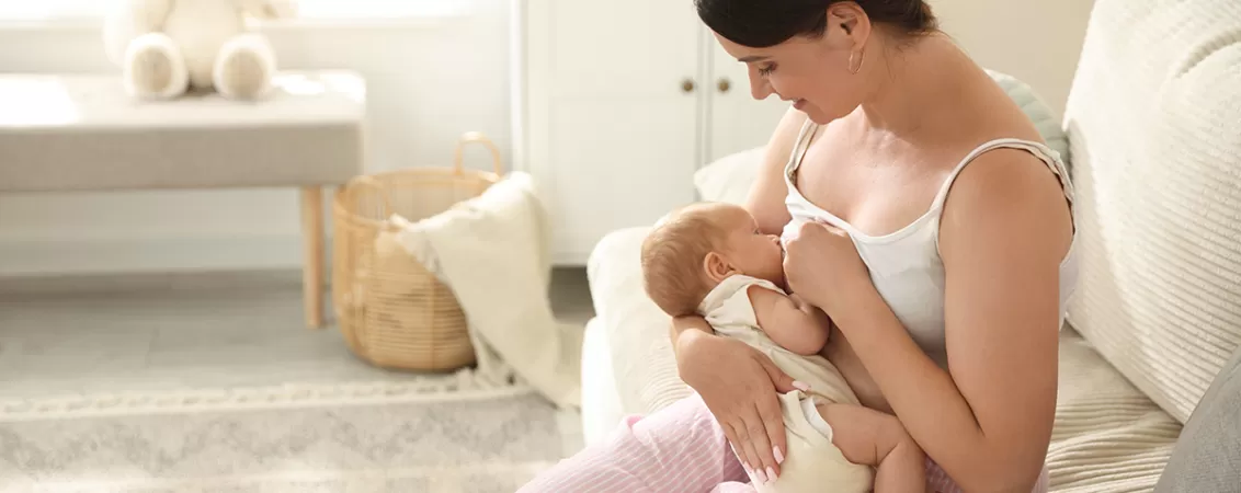 Femeie in perioada de lehuzie, alaptandu-si bebelusul.