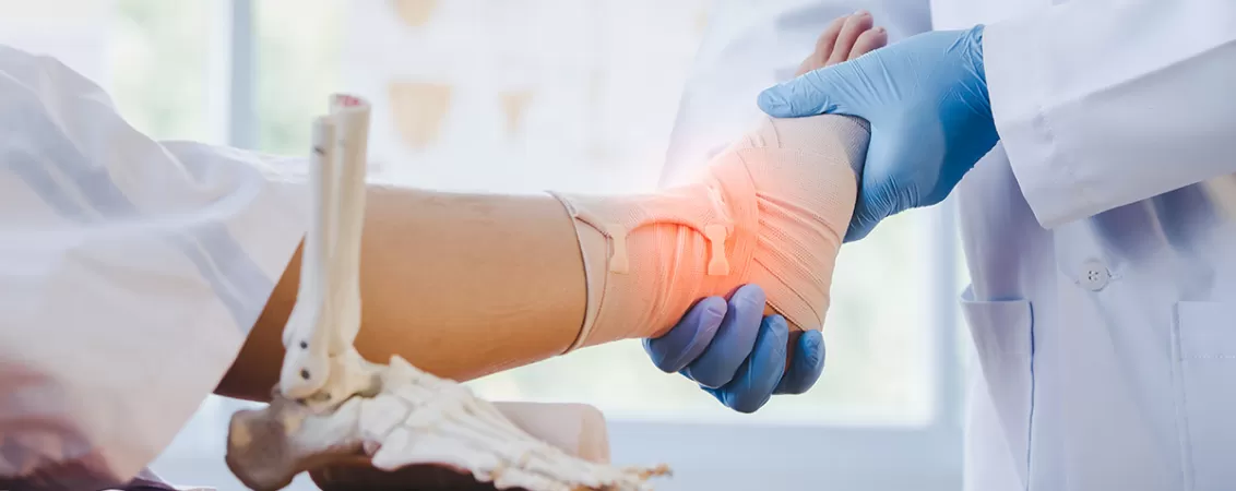 Medic ortoped examinand glezna unui pacient dupa artroscopie.