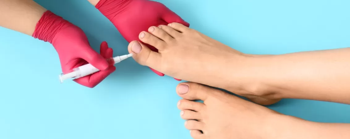 Pedichiurista aplicand ulei de cuticule