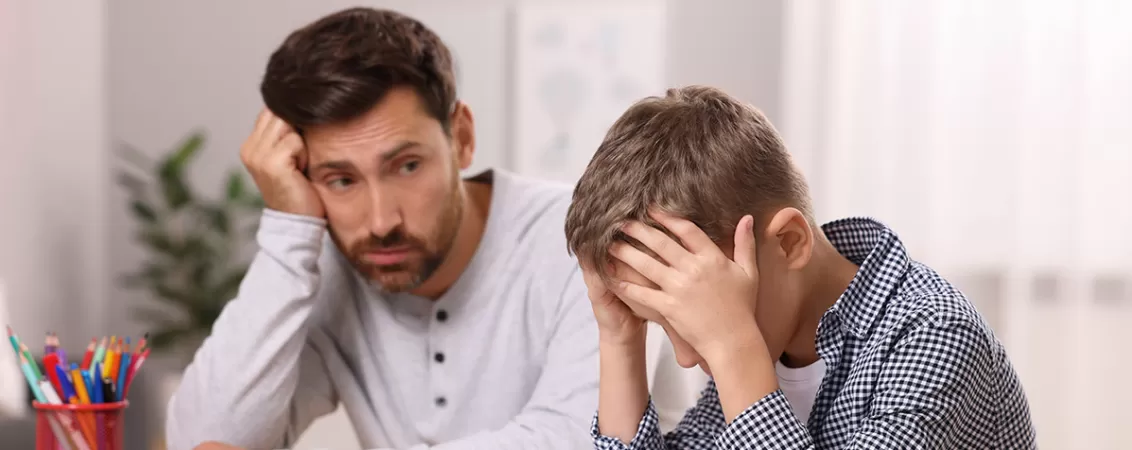 Tata incercand sa-si ajute fiul cu o tulburare de invatare sa citeasca.