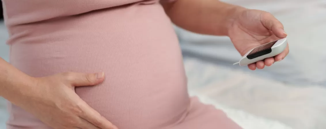 Femeie insarcinata verificandu-si glicemia acasa
