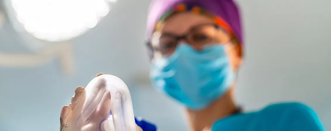 Medic inainte de interventie tinand o masca de anestezie