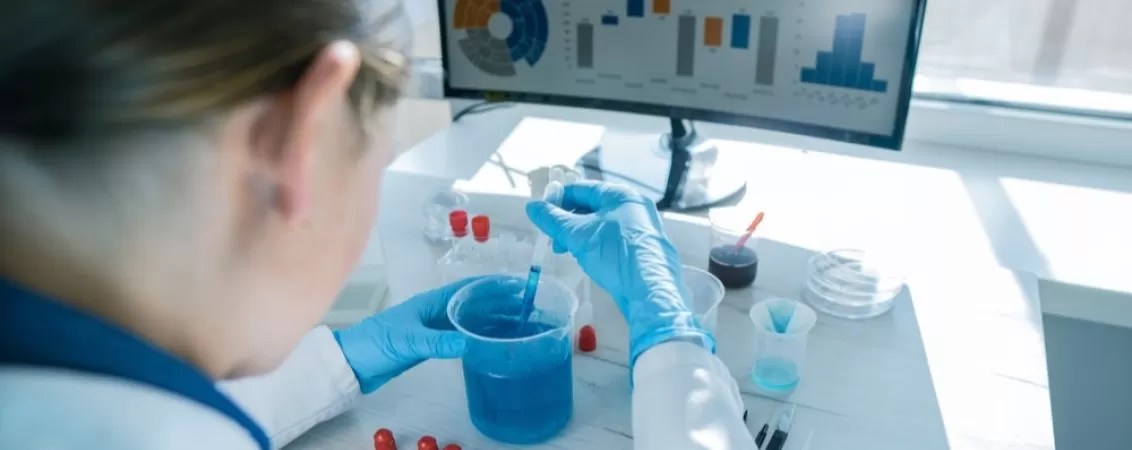 Cercetator lucrand cu material genetic intr-un laborator