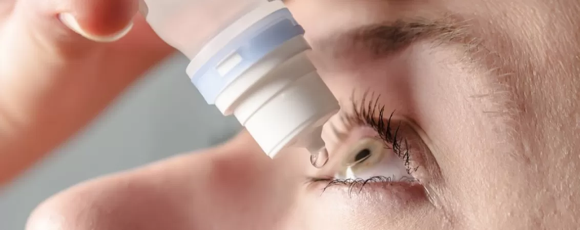 Femeie care isi administreaza lacrimi artificiale
