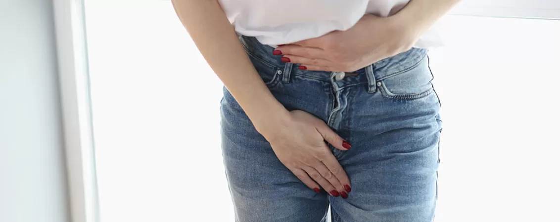 Femeie isi tine zona abdominala inferioara din cauza disconfortului pelvin