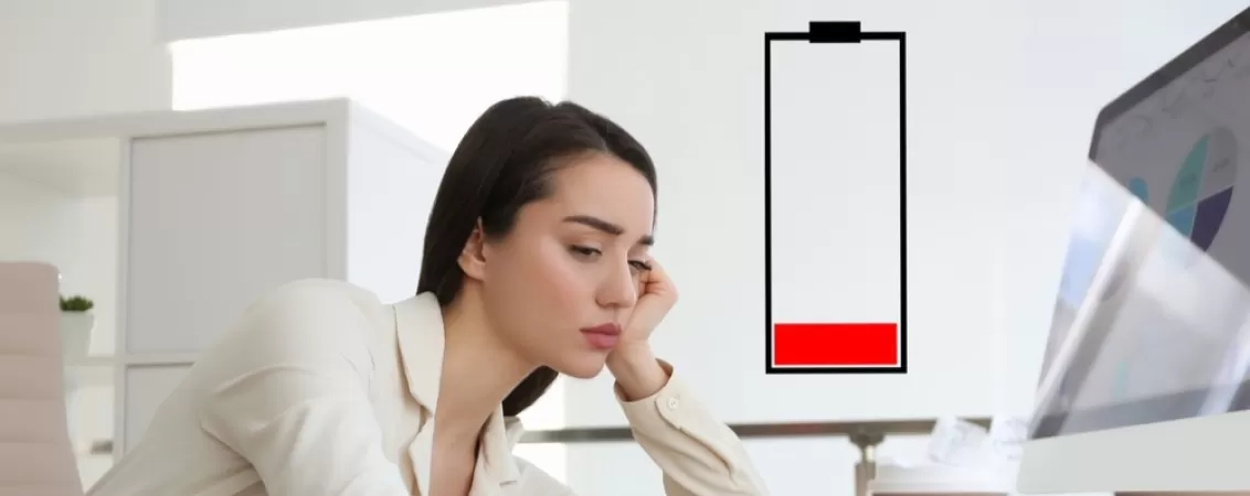 Ilustratie a unei femei epuizate la birou, simbolizand oboseala si lipsa de energie